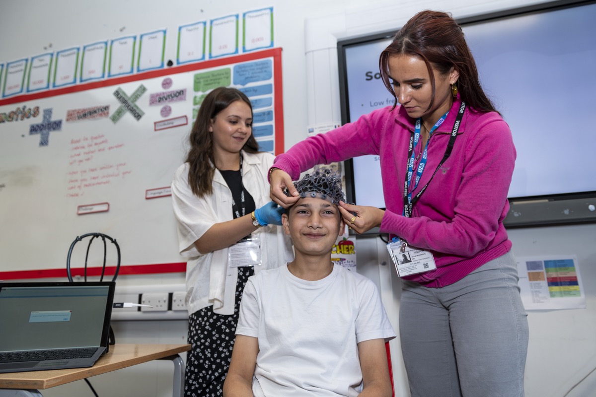 A researcher setting up an EEG headset on a participant